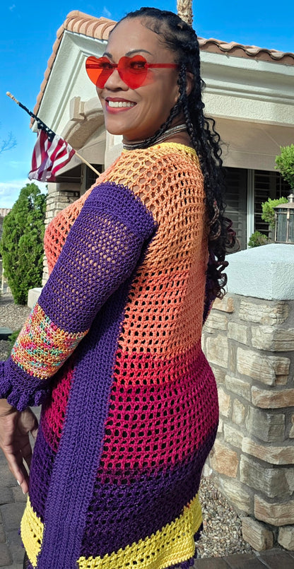 Spectrum Sunset crochet dress worn — side and back view, purple sleeve with rainbow cuff band