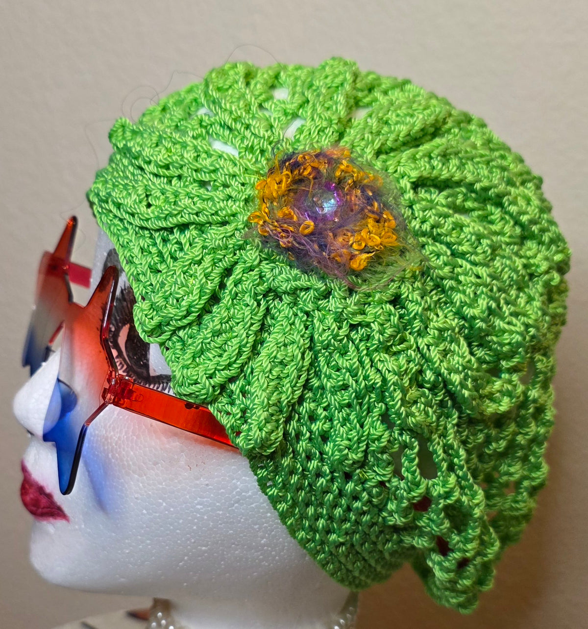 Verde Bloom Hat side close-up — signature golden-purple boucle bloom with galaxy-vibe button center