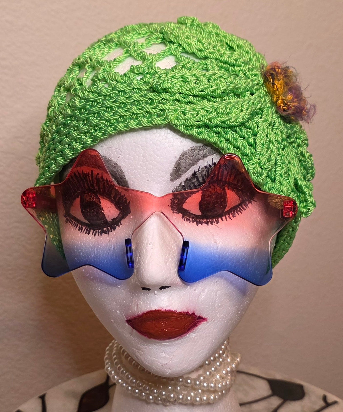 Verde Bloom Hat front view on mannequin head — lime-green openwork crochet cap with signature boucle bloom and galaxy button