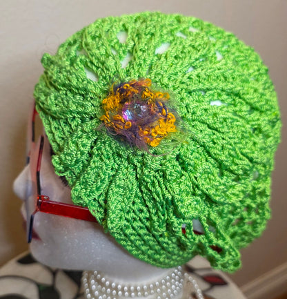 Verde Bloom Hat side view with bloom — lime-green lattice openwork crochet cap on mannequin head
