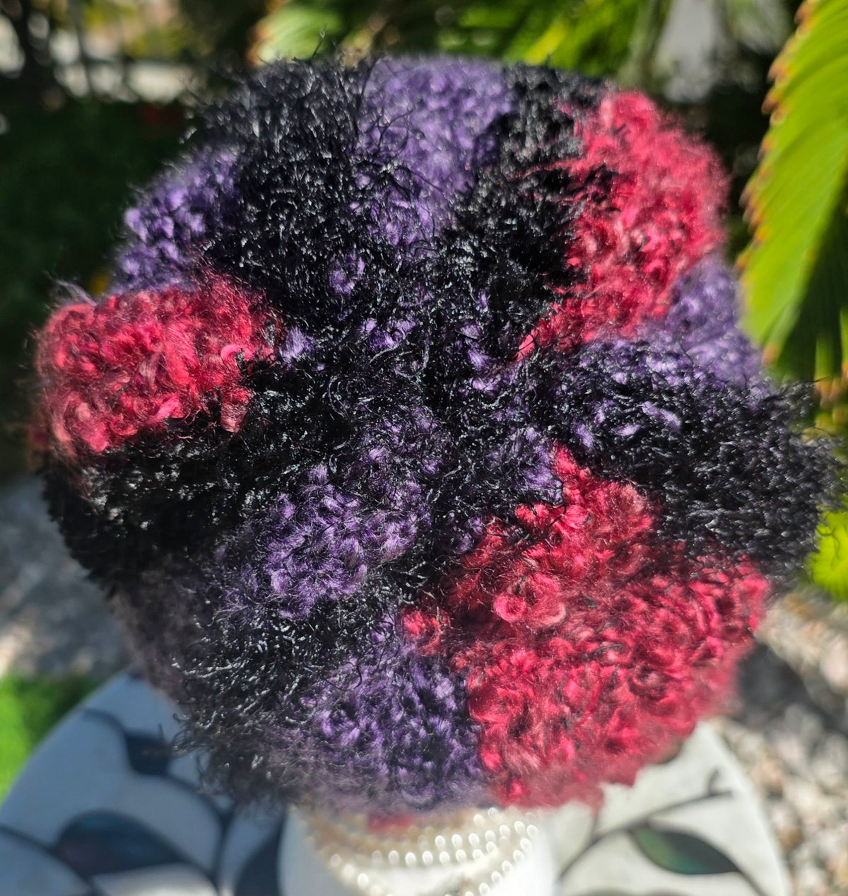 Top view of the Amethyst Queen Hat showing the black, purple and crimson crochet texture